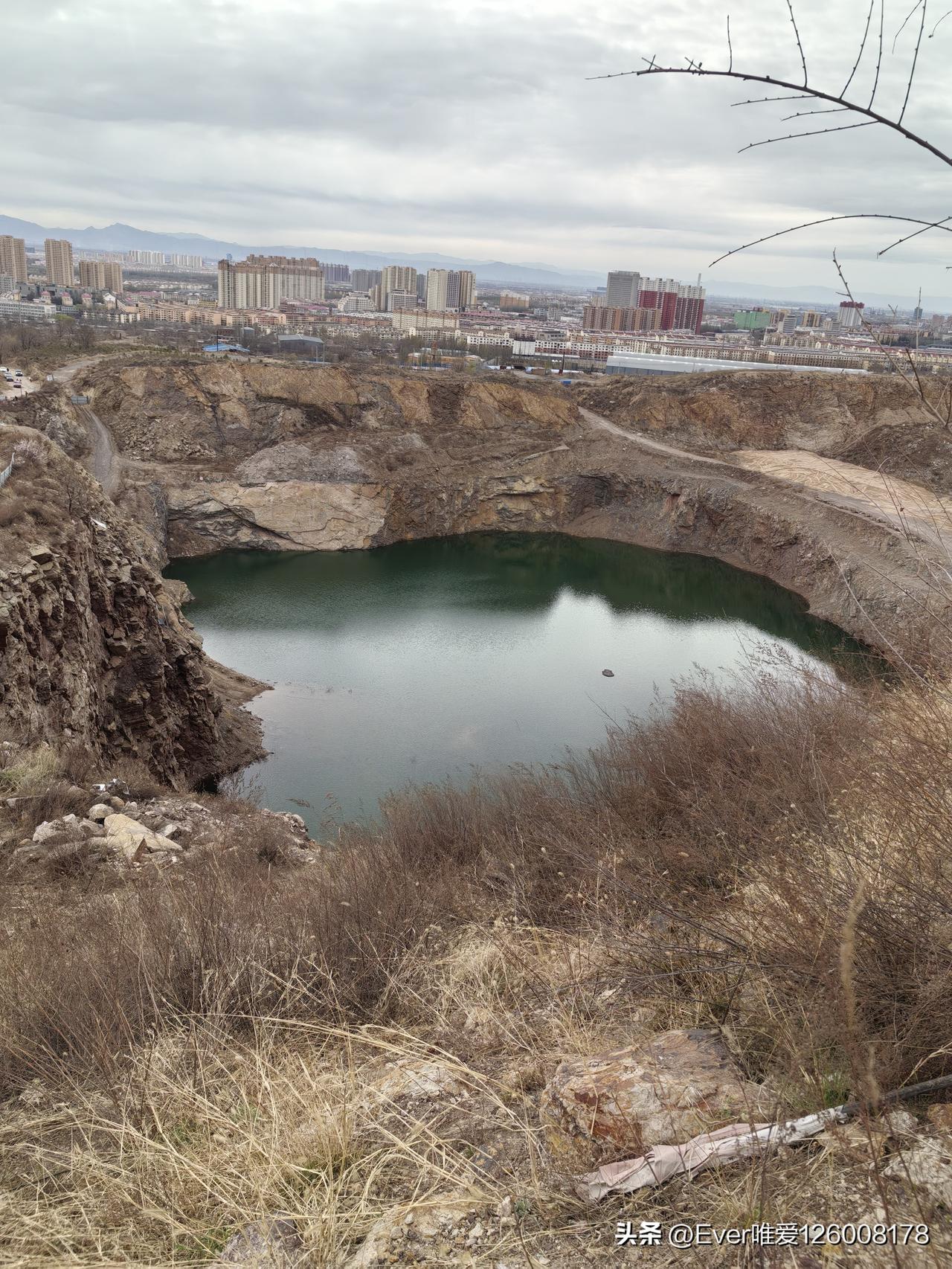 城市与荒漠的对比，静谧的湖水映照着远处的建筑群。