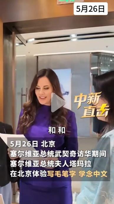 5月26日武契奇妻子塔玛拉秀书法，人美字也美；只见她穿着紫裙，拿着毛笔写了一个“