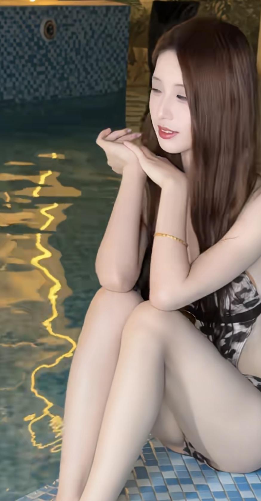 女儿坐在泳池边，看着水面发呆。