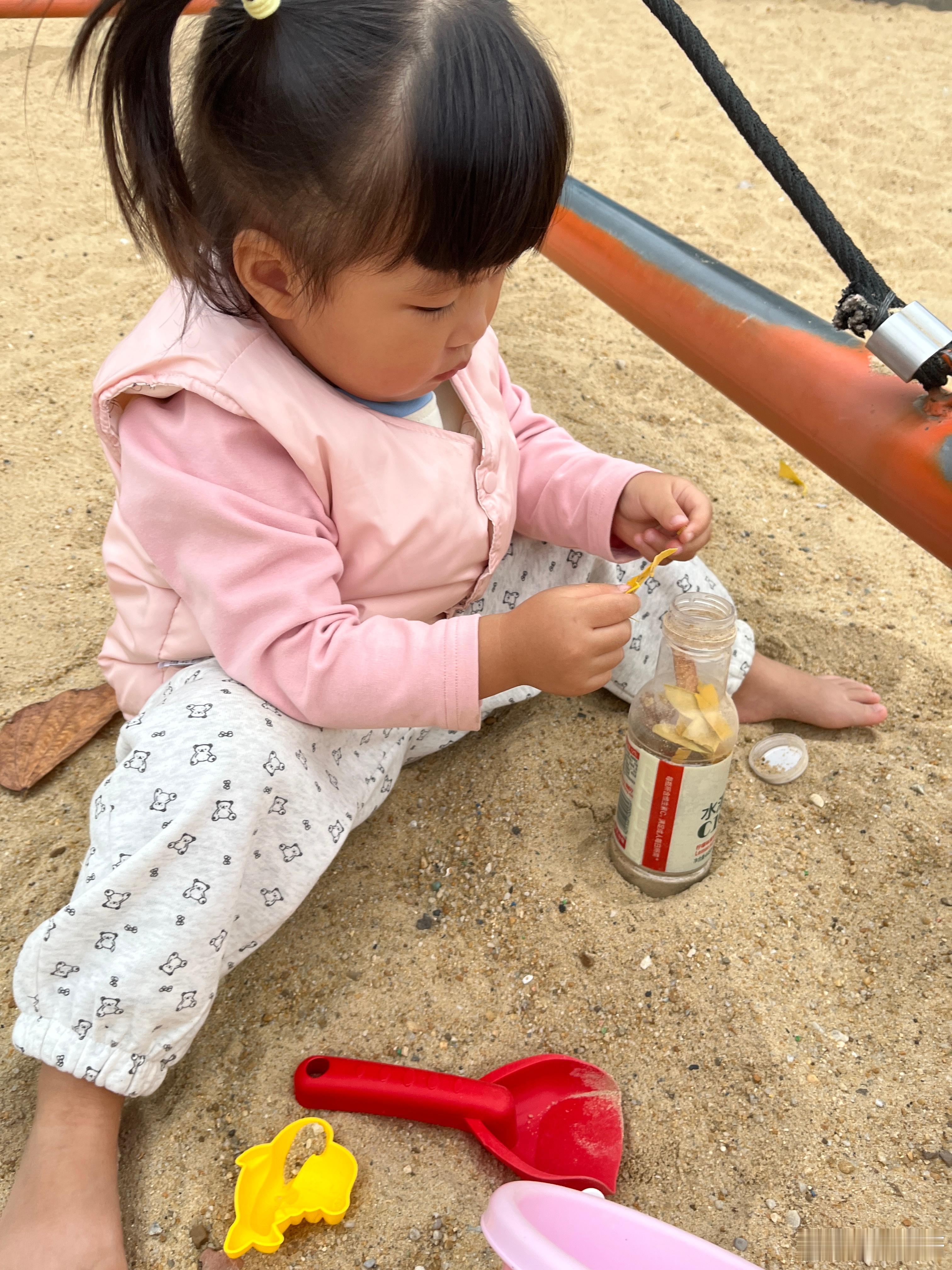 放学了，来玩沙子。阴沉沉的天，想下雨的感觉。要做点心给我吃，还加了树叶，说好美味