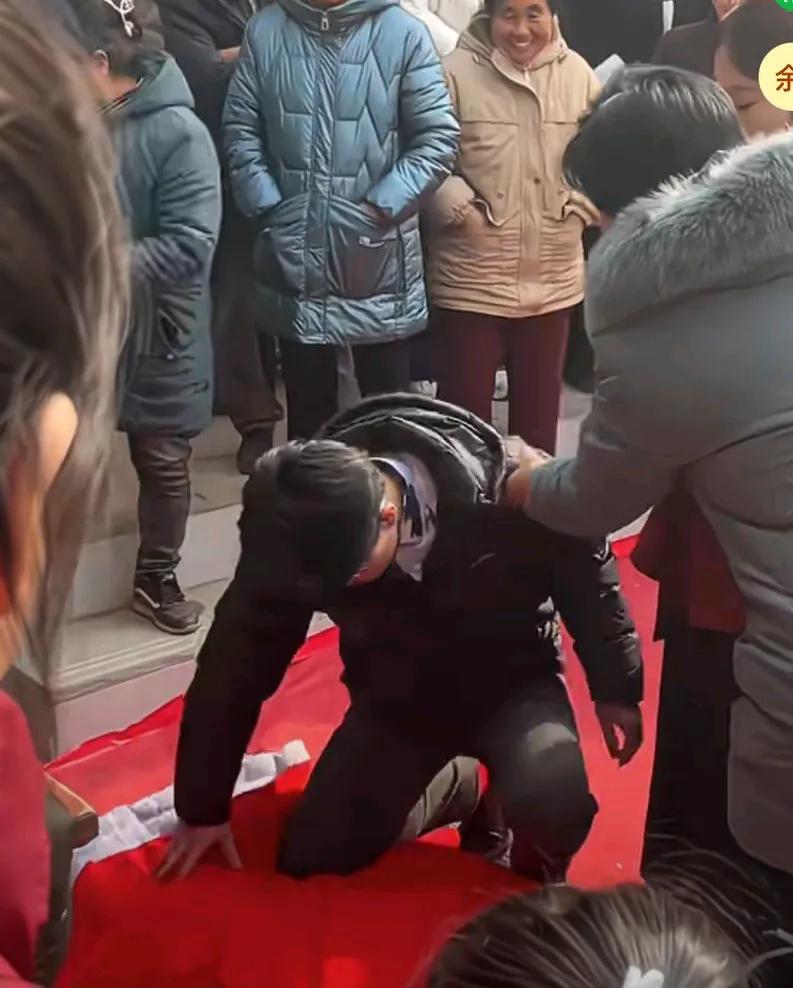 结婚当天让新娘磕头认亲，新娘不愿意，
新郎主动出面化解尴尬，只见新郎替新娘跪下磕