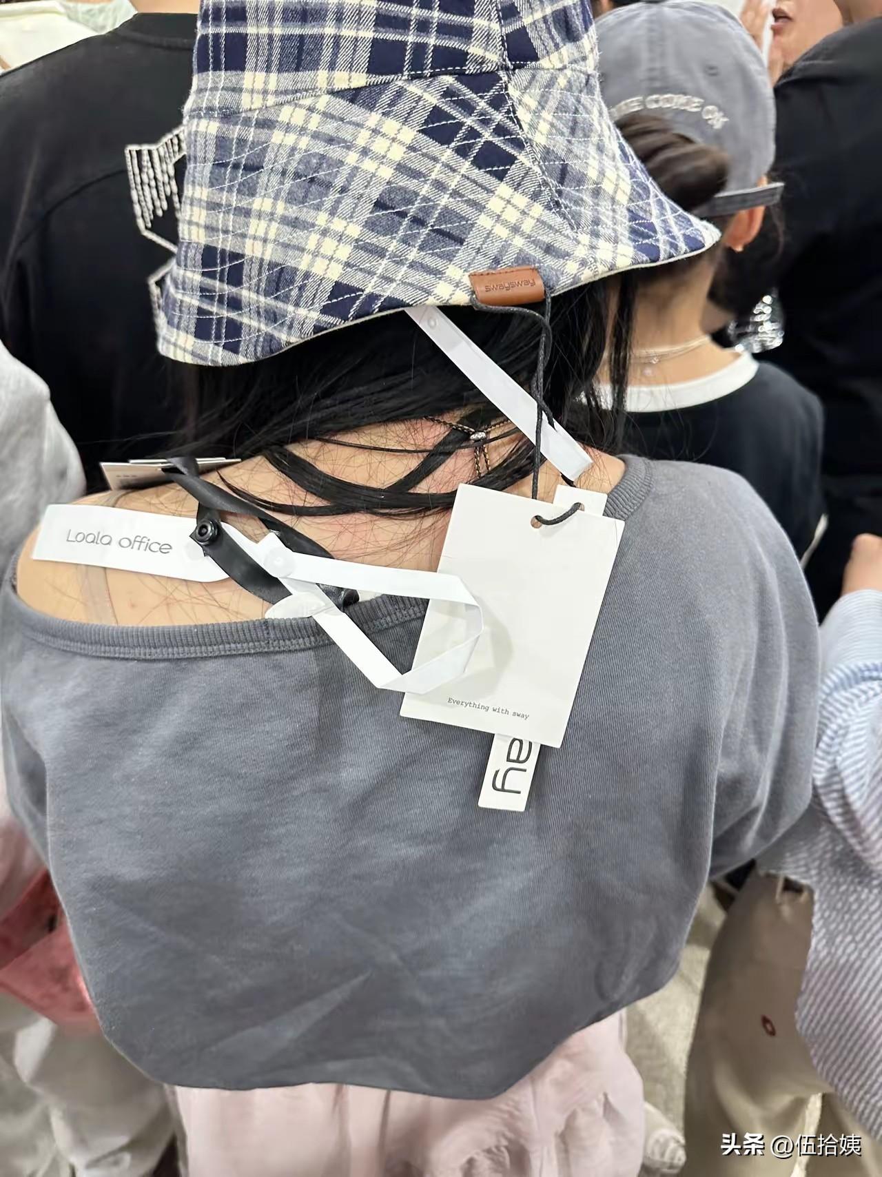 看到网友晒出来的随手拍，她前面女士帽子、衣服的吊牌都没摘，就这么明晃晃的挂着，穿