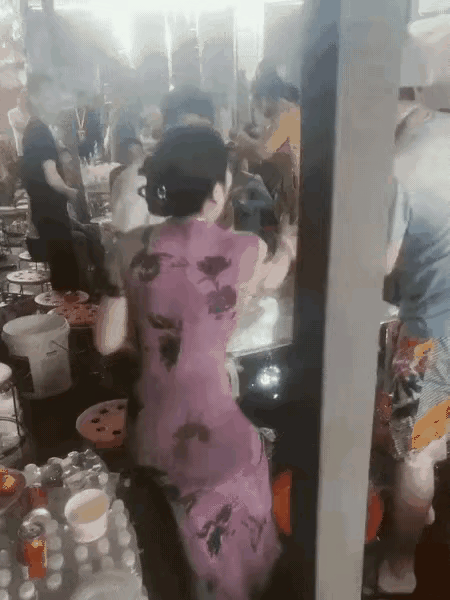 这是主家待客，女子招待亲朋好友一起聚餐。女子身材匀称，长的漂亮，穿着旗袍，有一位