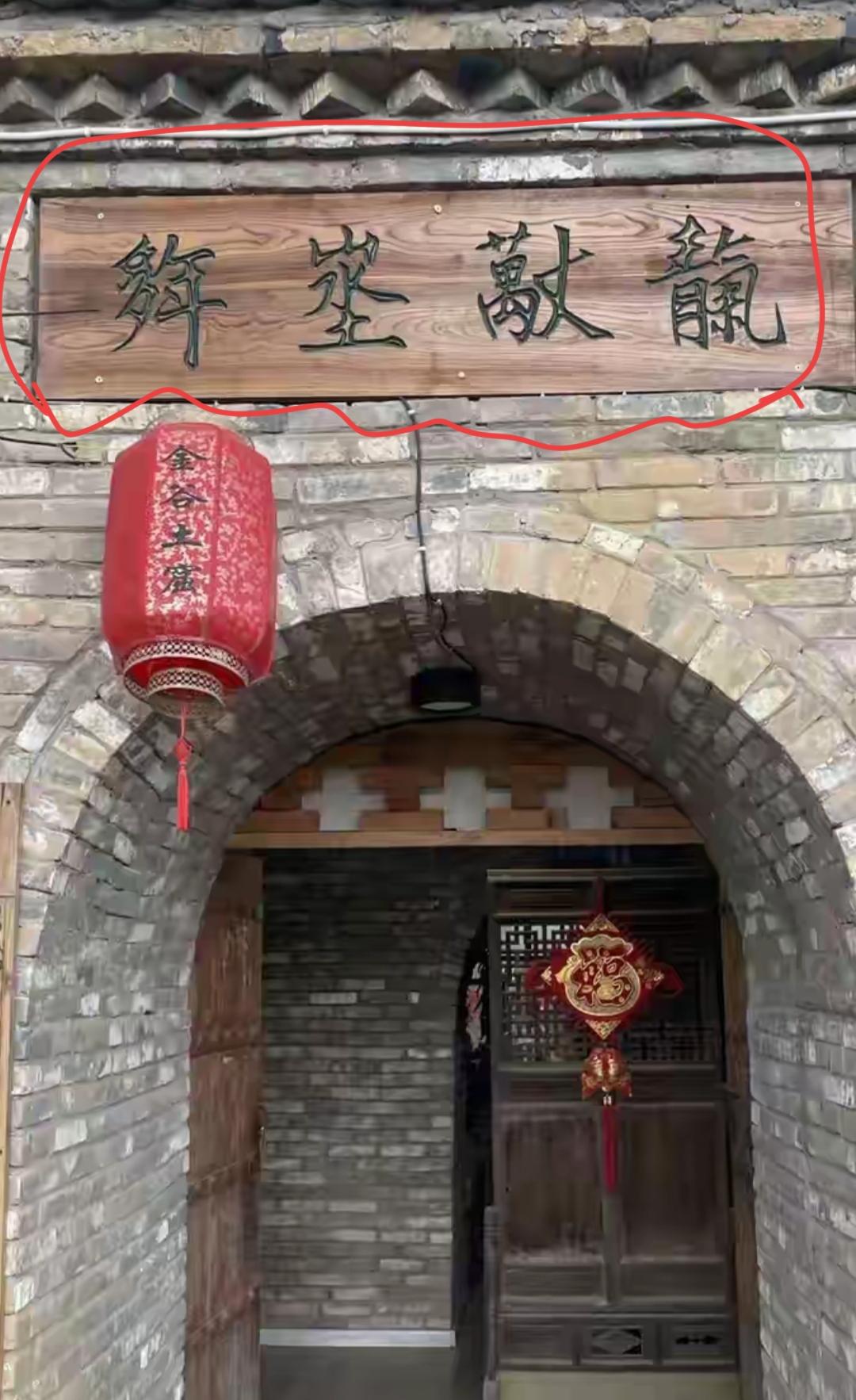 这个门上挂着两个大红灯笼。大家看看屋檐下的四个大字怎么念？有人能读出来吗？[作揖