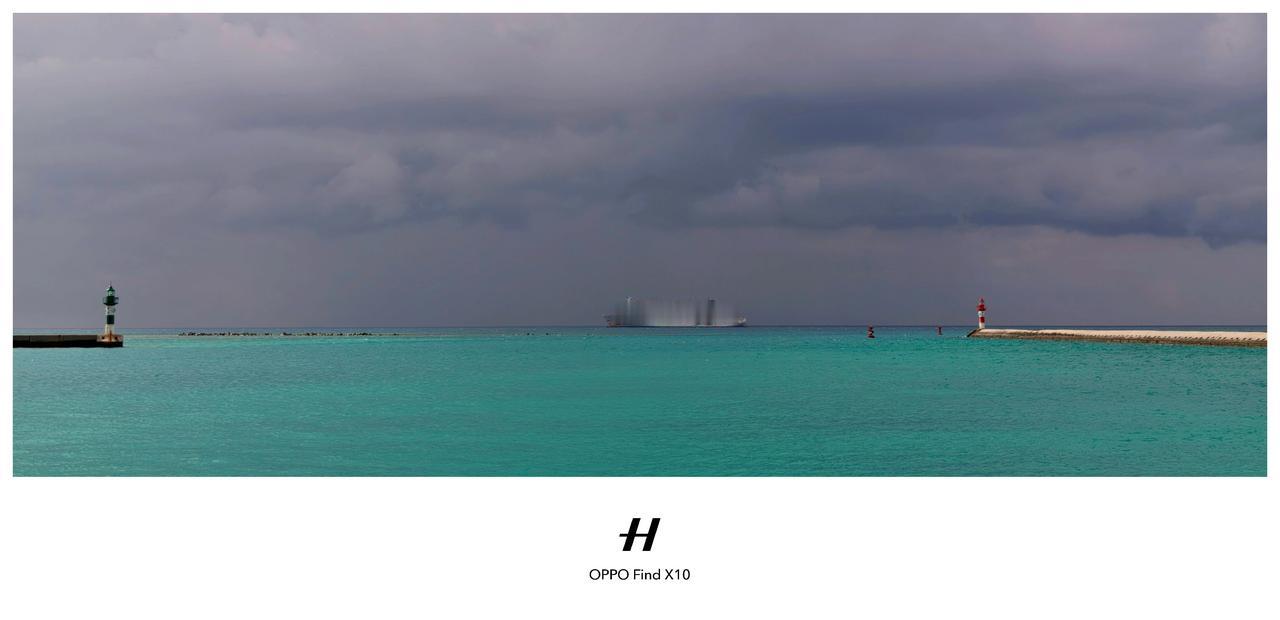 乌云低垂如墨，海面却泛着青蓝的光，仿佛天空与海洋在无声对峙。远处那艘游轮，像一枚