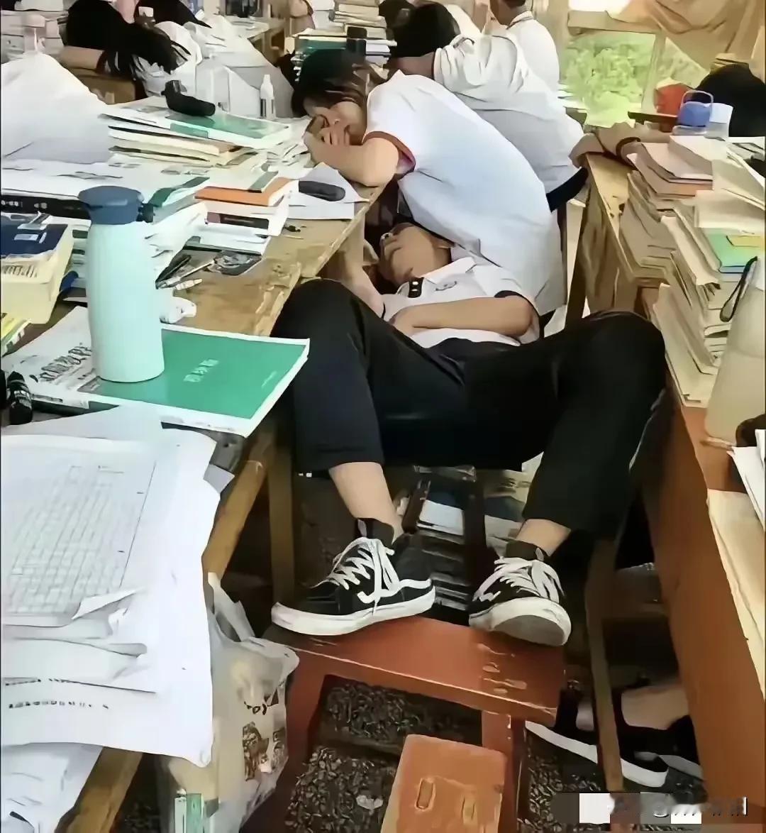 仔细看图：这是学生的午休时间，同学们都伏在桌子上午睡，这个男生很特殊，睡在了人家
