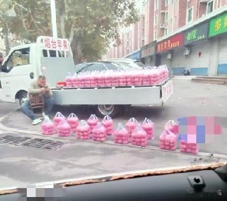 近日，山东淄博一大哥在路边卖苹果，苹果放在袋子里是称好的，整整齐齐的放在一起，像