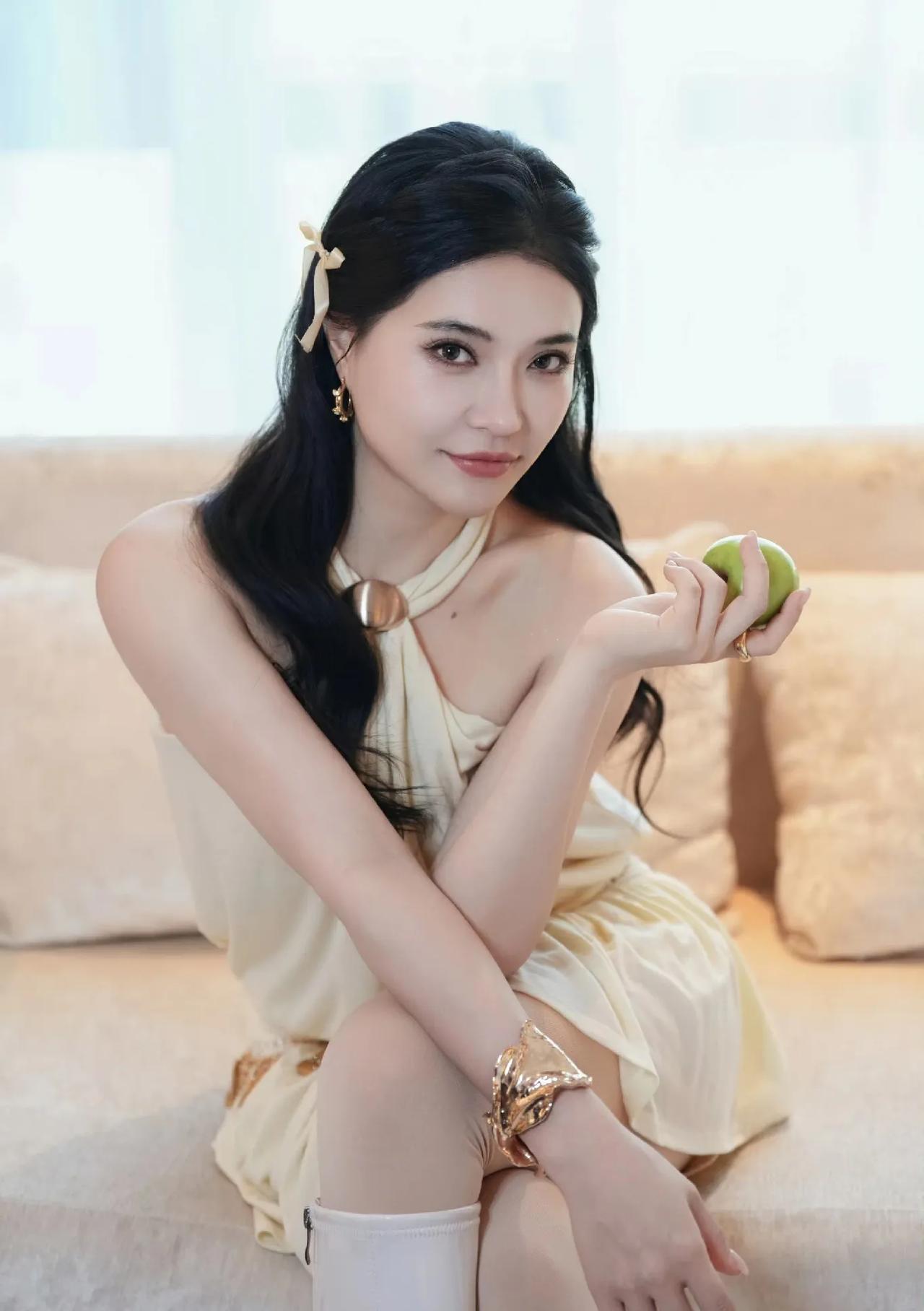 奶油调穿搭太显气质了，庄心妍这组造型温柔又有辨识度，挂脖裙搭配长靴，甜而不腻，日