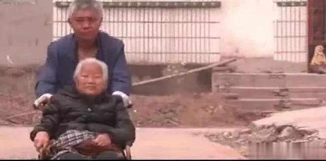 90岁的老人赵每天都坐在轮椅上。他在院外呼唤儿子的名字，但大儿子不开门。这是河南