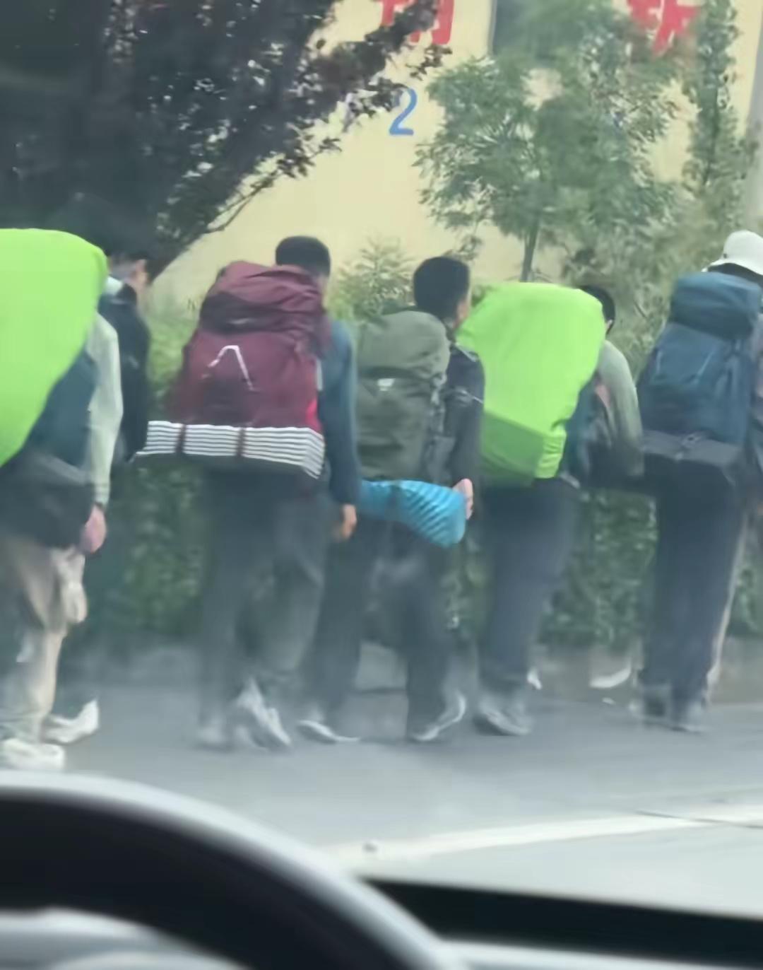 5月20日有网友途经盘山公路，偶遇一队装备齐全、步伐整齐的重装背包客，统一的荧光