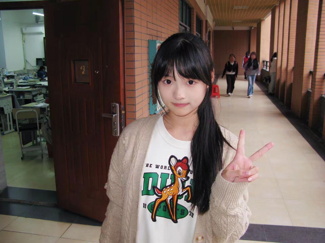 这个女孩在教室门口比了个V字手势。晒晒少女靓影