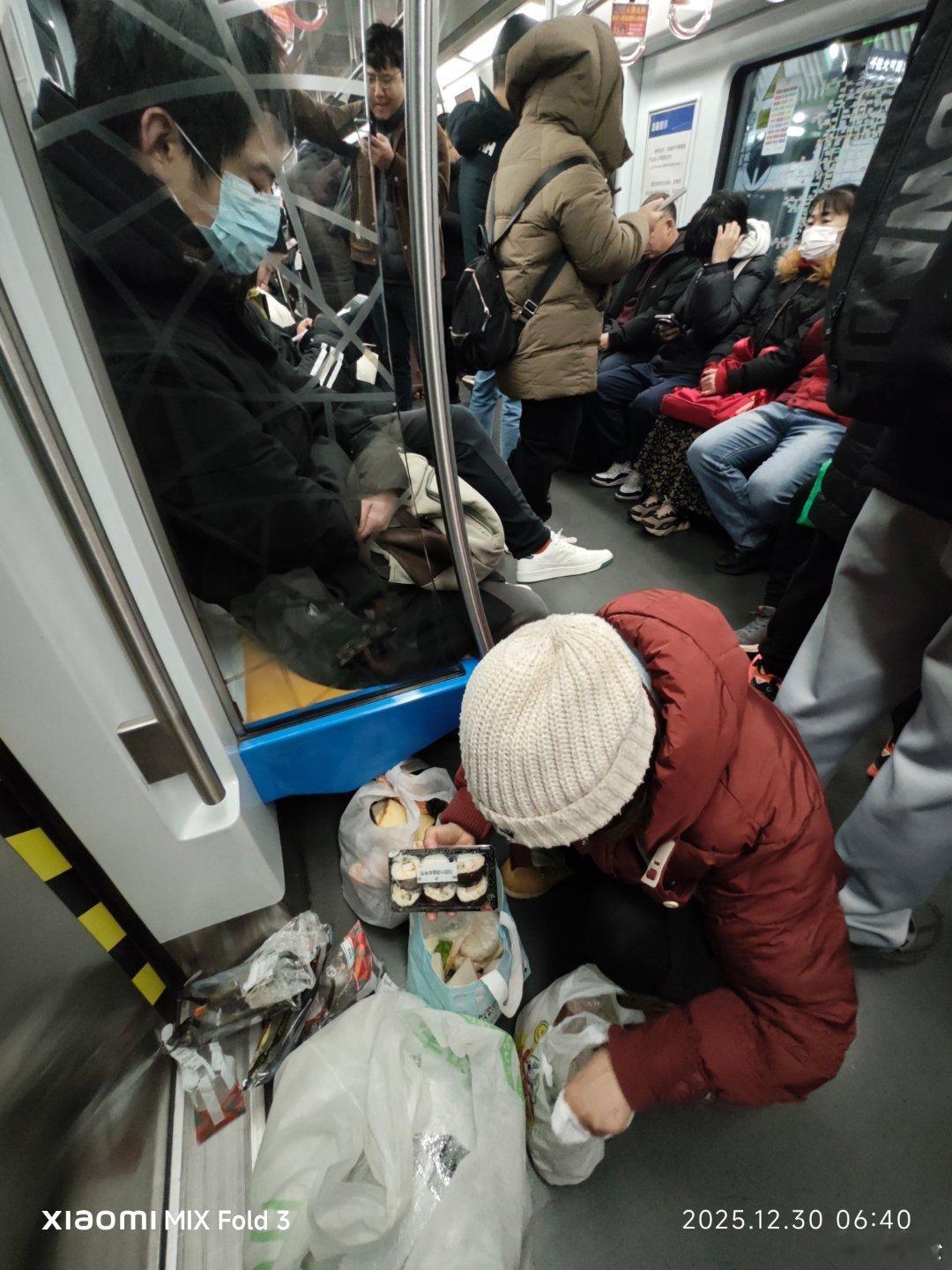 这个坐早班地铁的婆婆一直在不停地从小象购物袋里像变魔术一般取出各种食物来，有面包