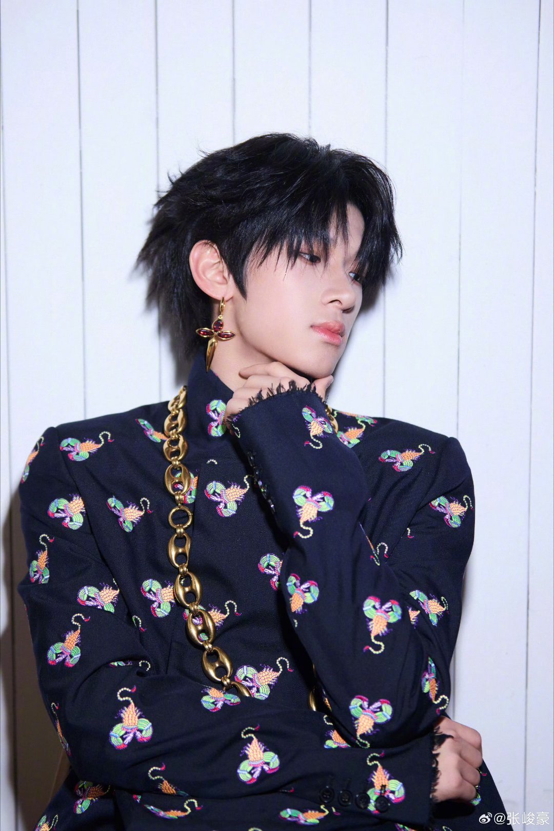 出席上城士非遗巡游展，他身着立领长袍，通体铺陈民族刺绣工艺；配饰选用粗金链与十字