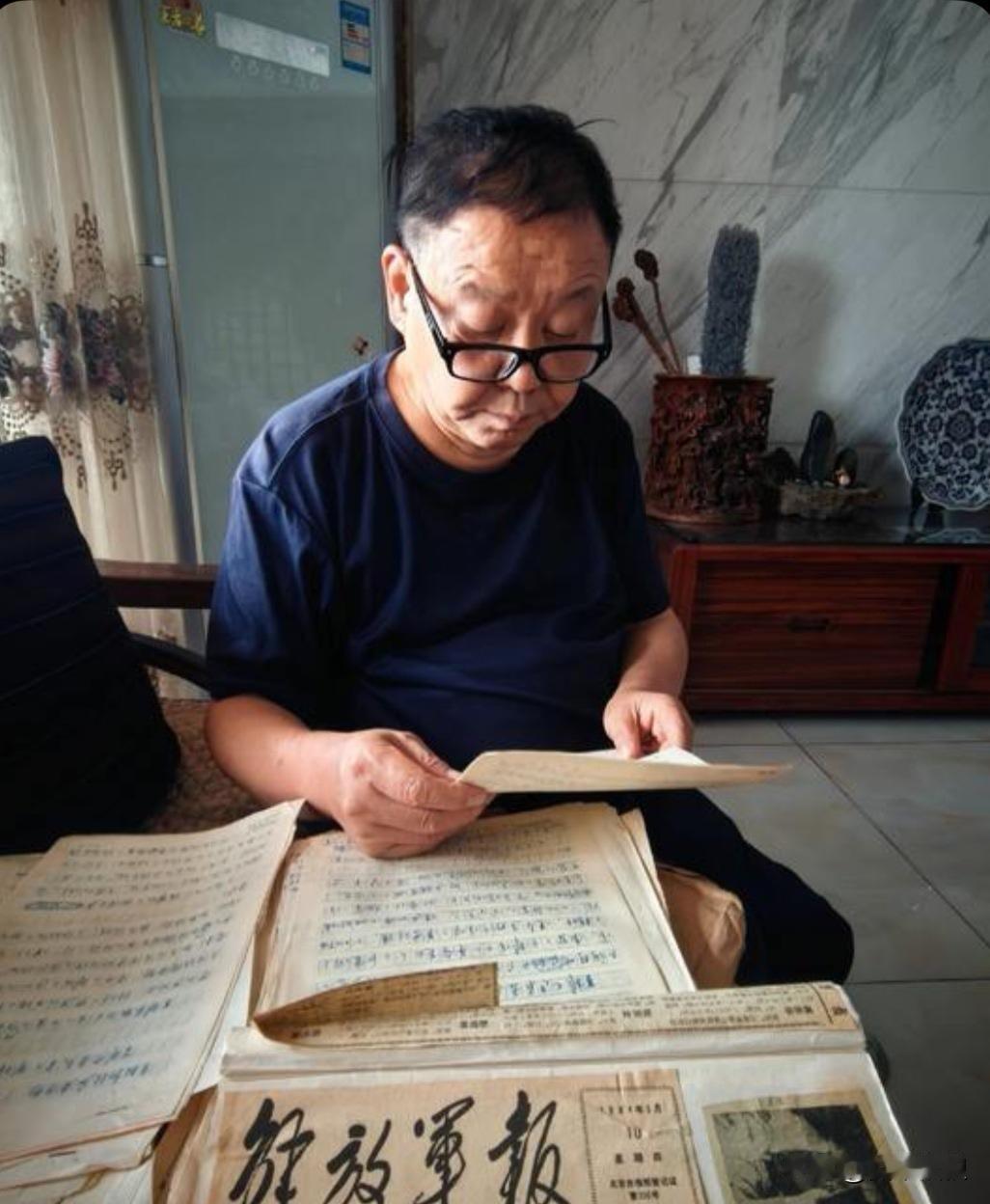 战地摄影师杨健翻阅着当年在战场上撰写的宣传英雄事迹的稿件。四十多年时光匆匆而过，