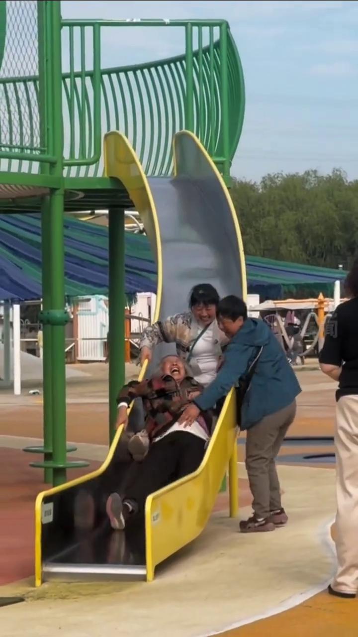 这一幕太治愈！两位女儿带80岁母亲玩耍。
网友：幸福具象化了。
