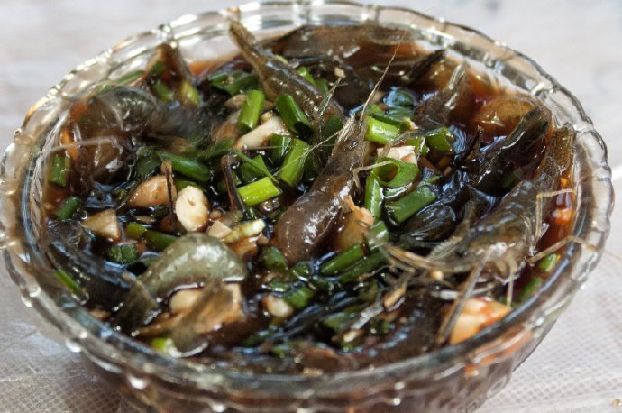 宁波过年味蕾记忆之醉虾把洗净的活虾放入玻璃器皿中，然后将黄酒或者白酒倒入完全浸泡