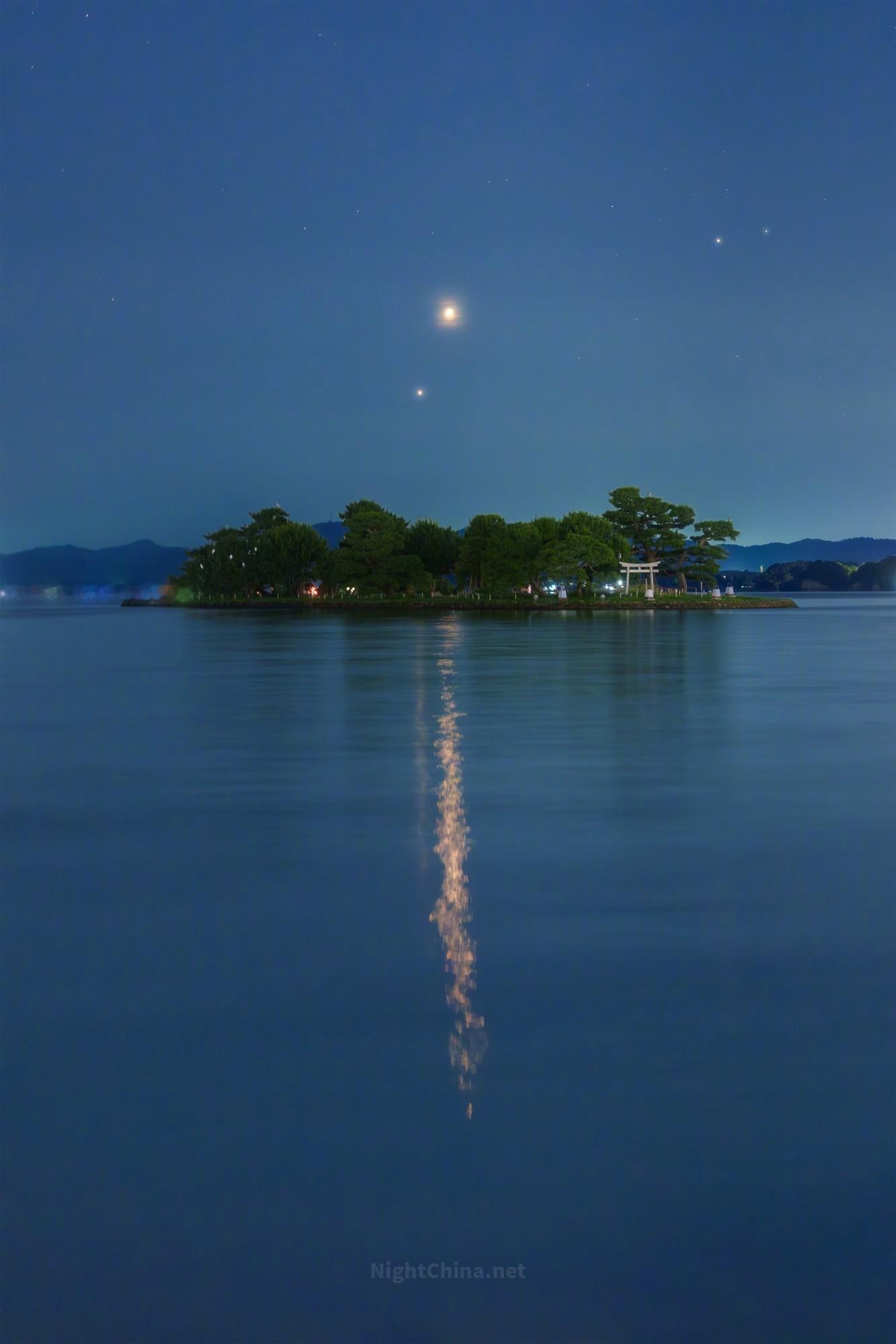 薄暮的宍道湖一片幽蓝，湖心小岛如浮在墨上的印章。金星与木星在此相约，靠得如此之近