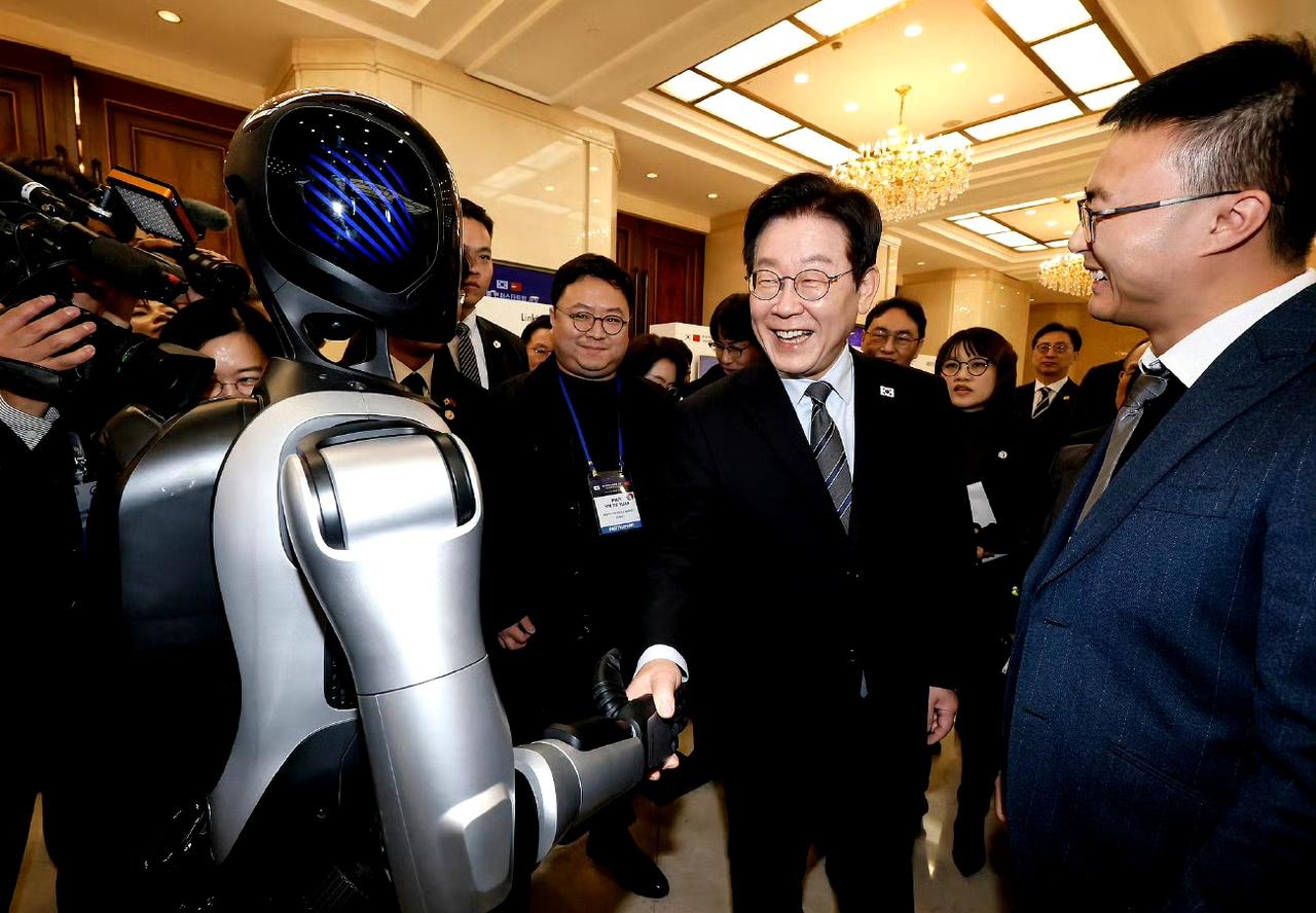 李在明造访上海，参观机器人并与之握手。 ​​​