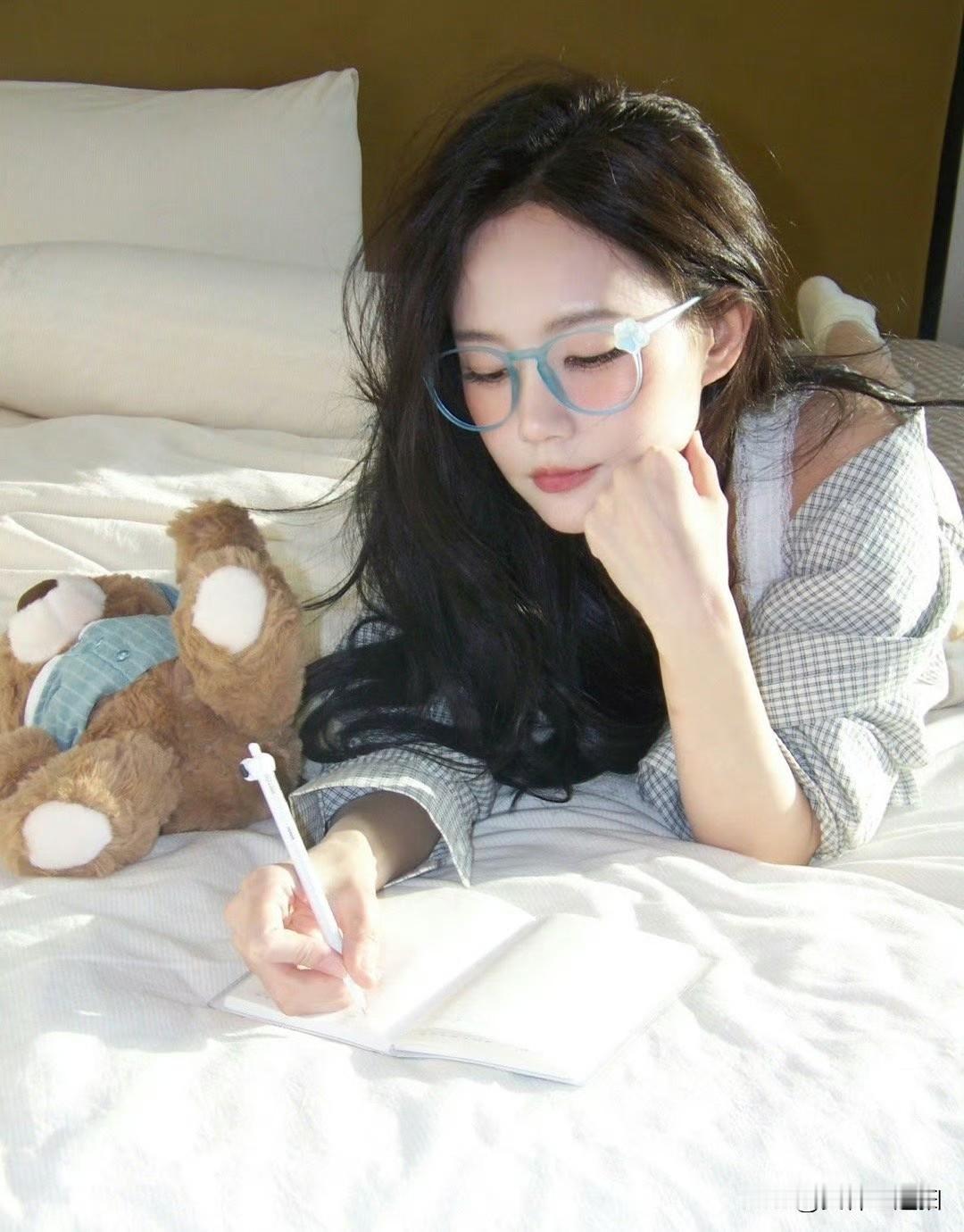 在阳光洒满的床上，少女沉思书写，静谧时光。