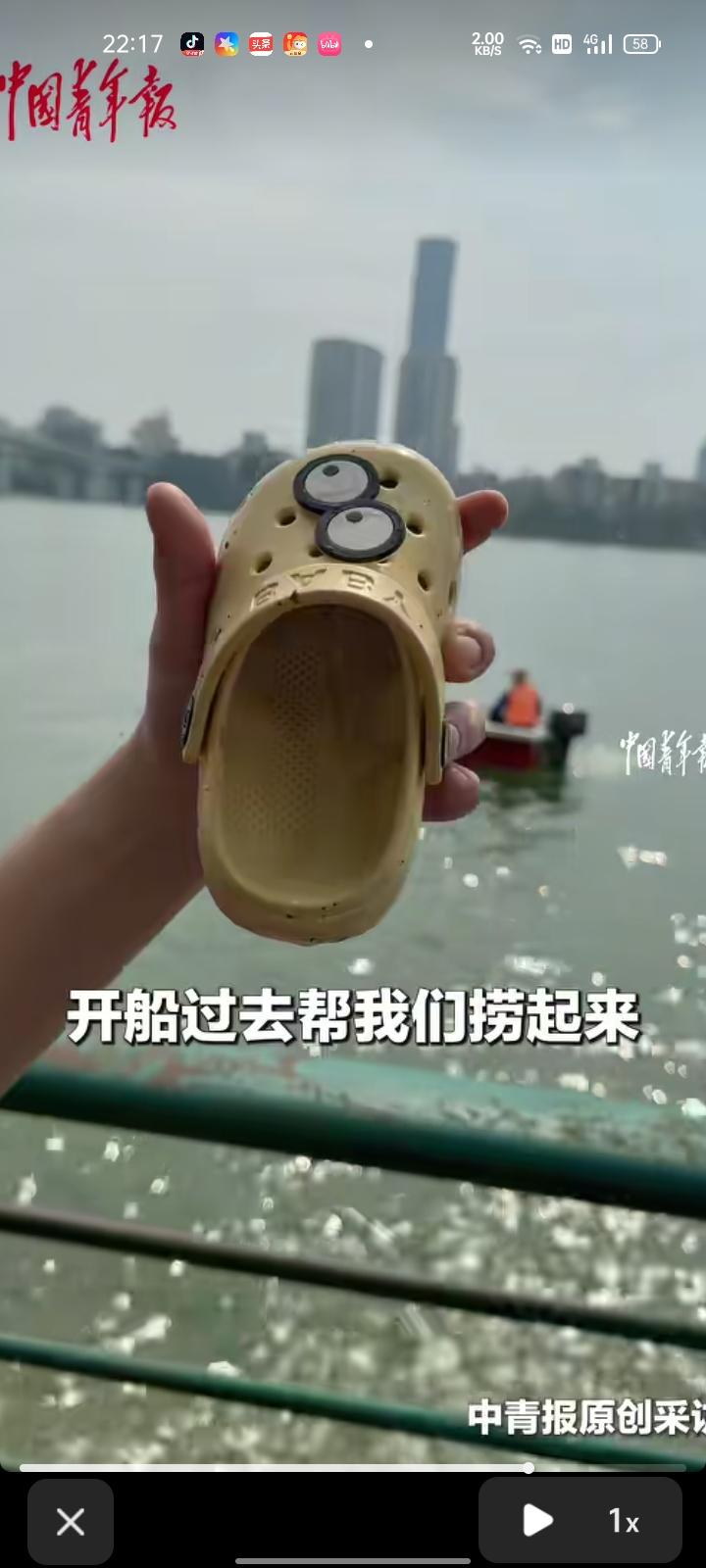 8月22日，广西柳州。女孩在河堤玩水时，一只鞋子被冲到江中。路过的船夫帮忙捞起鞋
