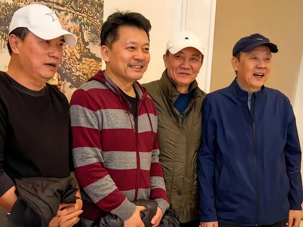 这张合照，我一眼就认出了穿着条纹帽衫、神采奕奕的何政军；戴着黑帽、喜容绽放的侯天
