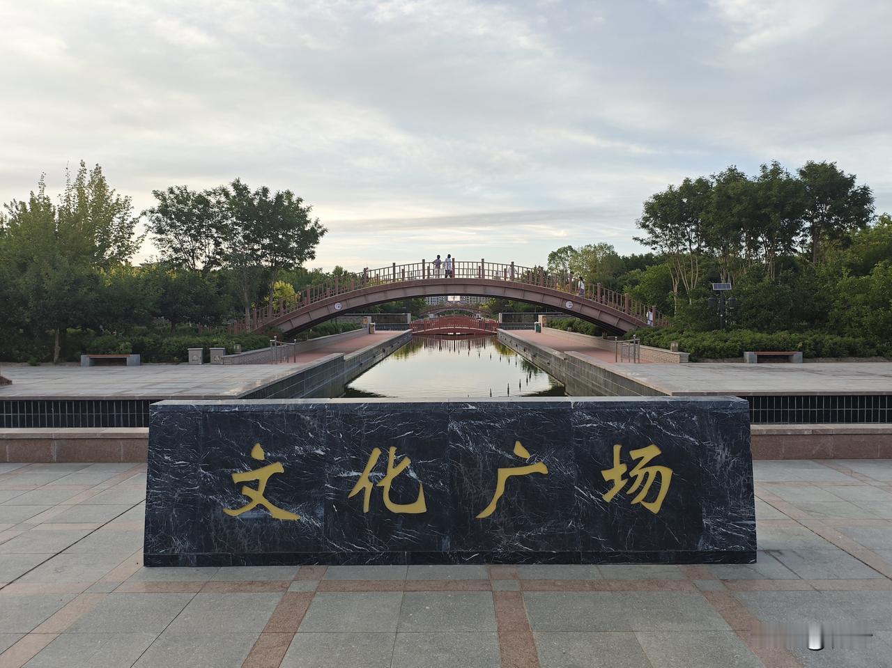 菩萨蛮·金塔文化广场
       云光轻裹长桥软，清波斜曳亭廊浅。石案载风闲，