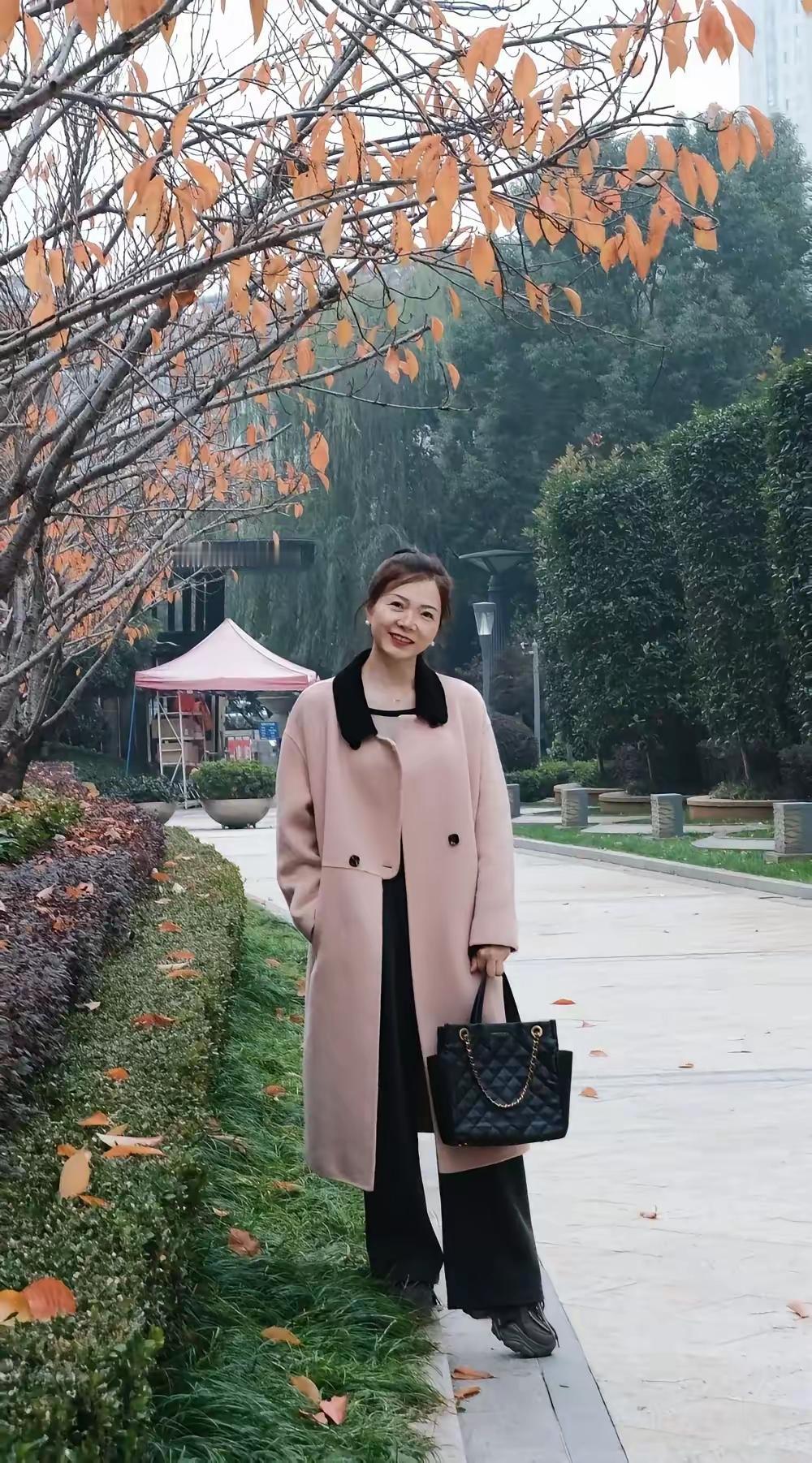 菜市场里那个穿米色风衣的阿姨又出现了。她挑西红柿的时候，手指又细又长，腰板挺得像