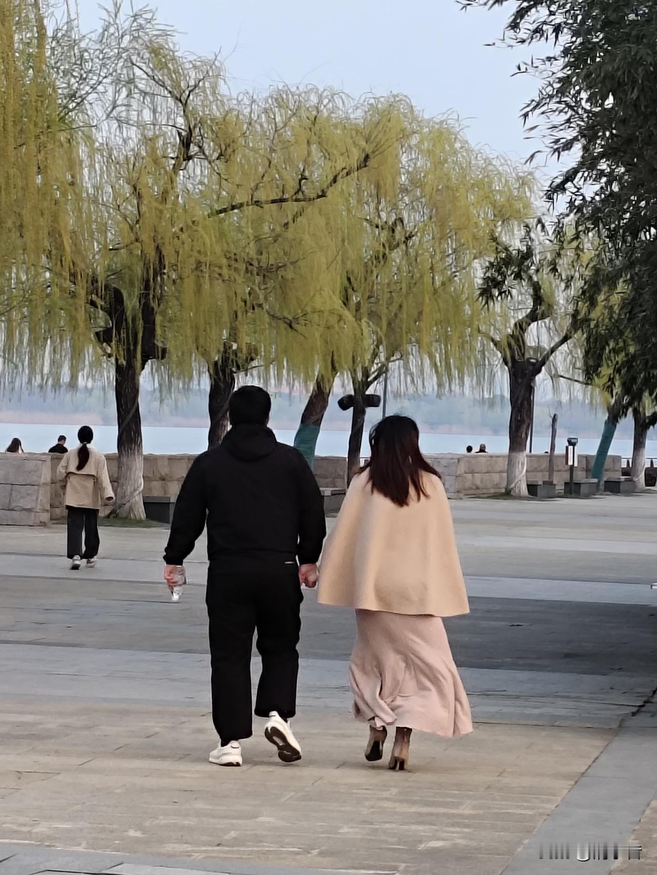 在公园逛，看到一个美女，穿件短斗篷，配条鱼尾长裙，蹬个细高跟鞋，可美可美了。
