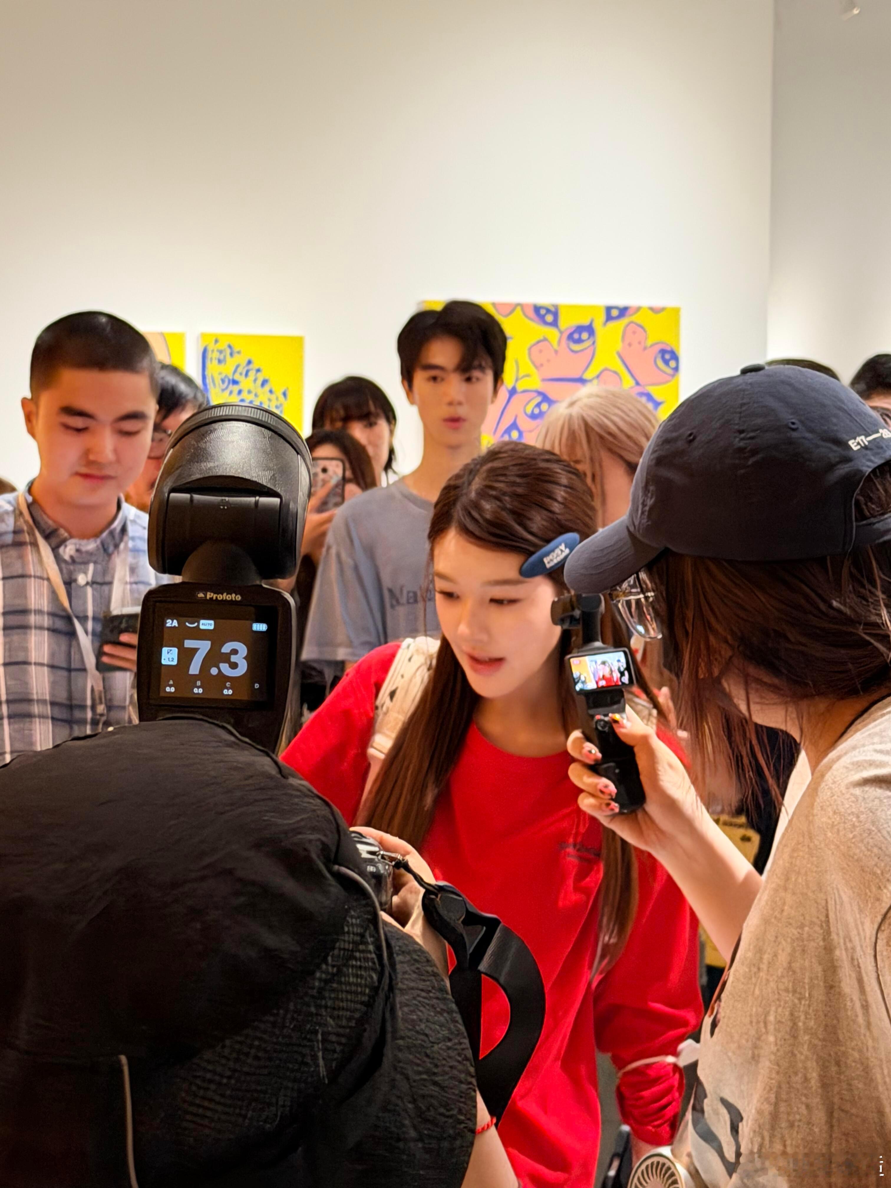 网友逛展偶遇露思，一身红调穿搭在人群里格外亮眼，长发搭配撞色发饰灵动可爱，休闲私