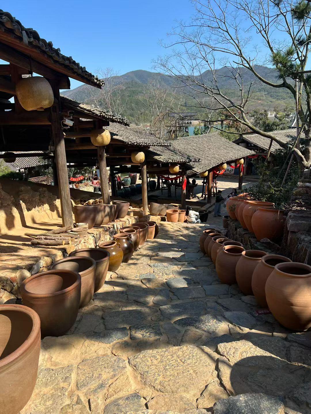 新年爱好打卡老檐挂着暖黄的灯笼，石径旁陶瓮排得妥帖——是山野里被时光慢炖过的烟火