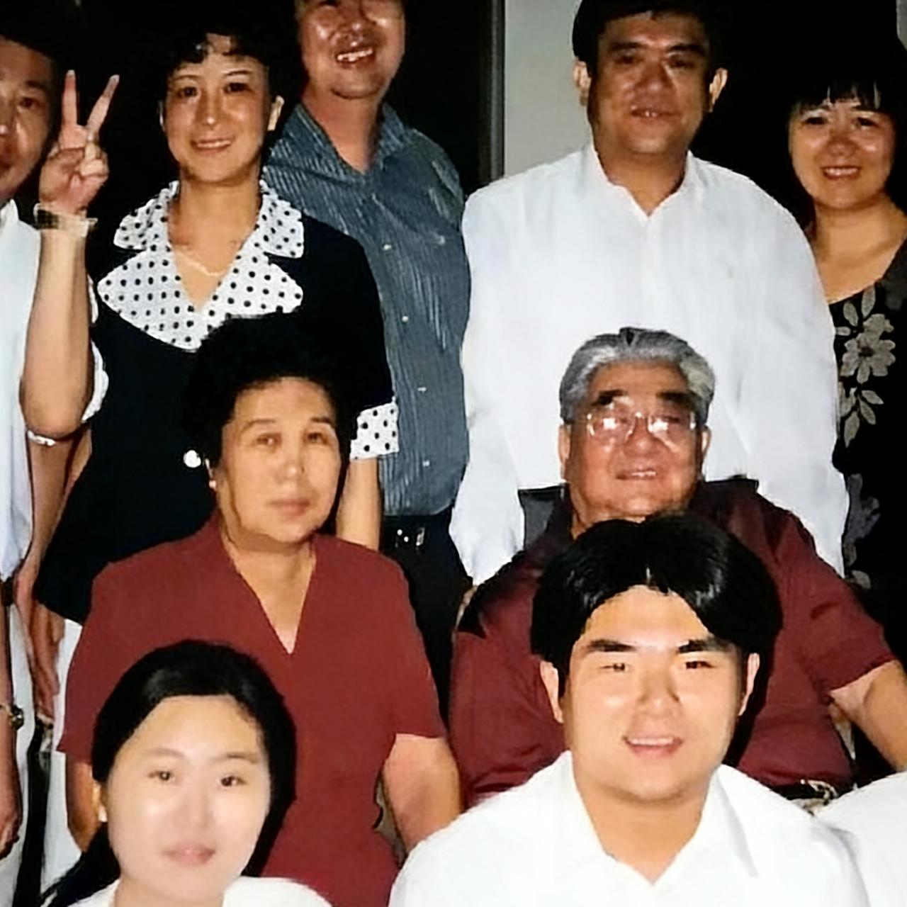 90年代，韩培信和家人，一张温馨的合影，镜头中的他和妻子李立英并肩而坐，脸上挂着