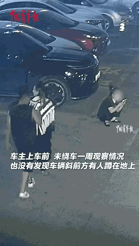 近日，新疆乌鲁木齐，一男子去开车时，没有发现蹲在车前玩手机的女子，而女子则全神贯