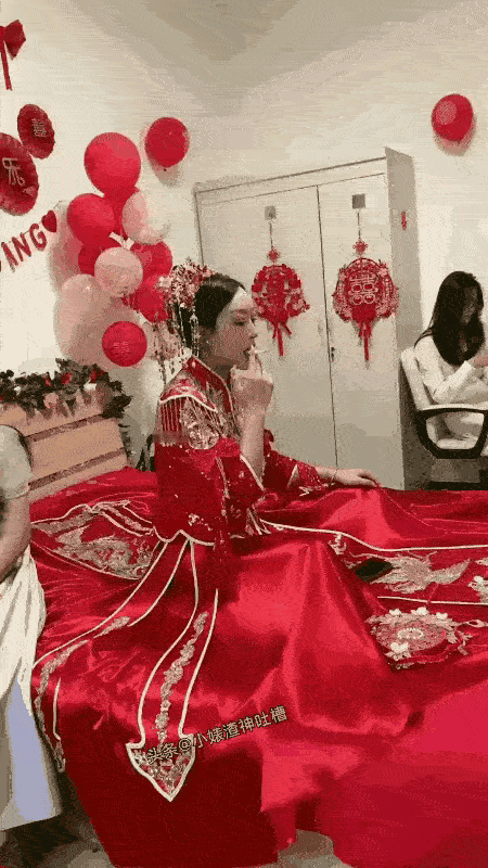 惊呆了！
一位新娘，穿着漂亮的婚服，坐在床上，手里叼着一根烟，口里不断的吞云吐雾