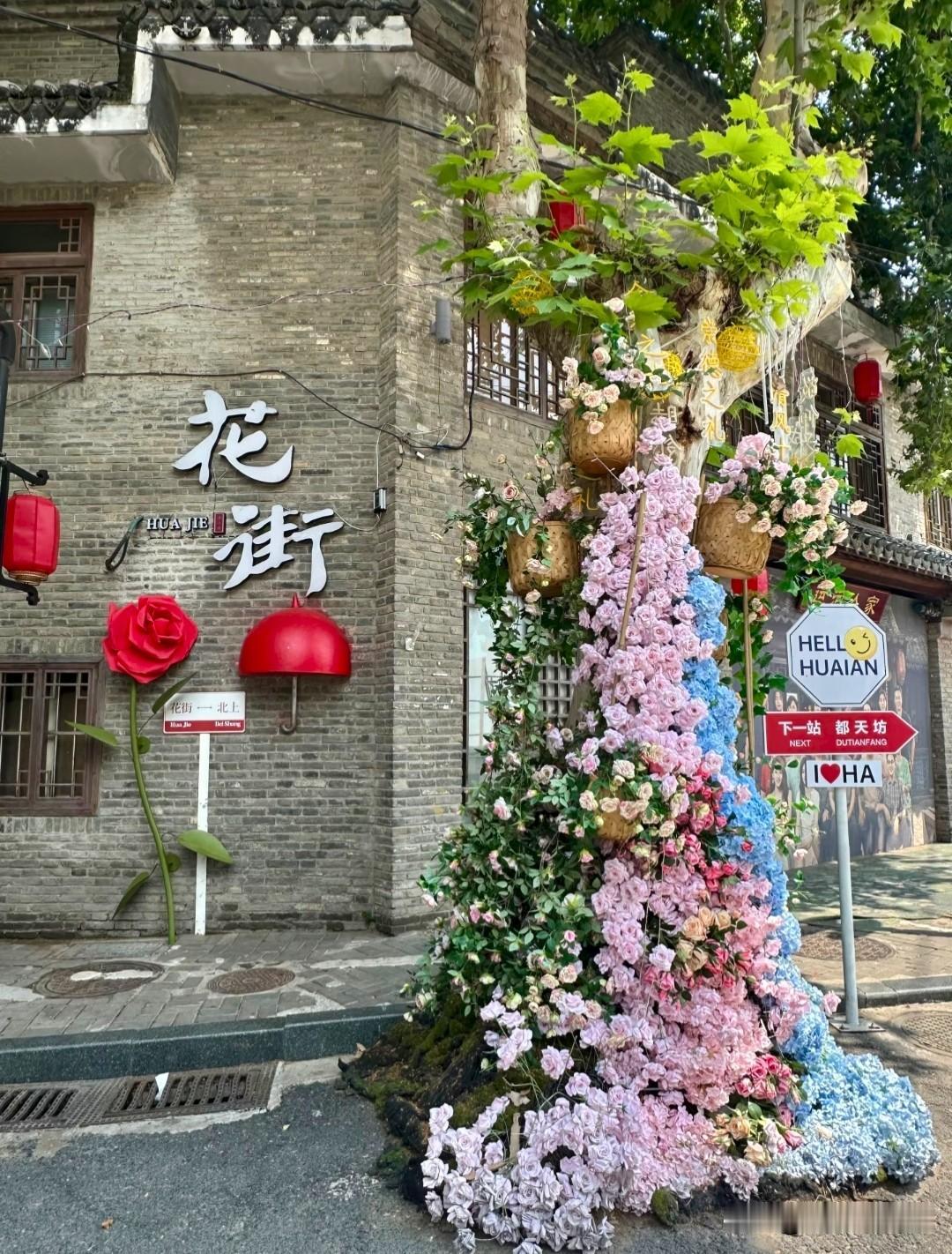 被时光打磨发亮的青石板路蜿蜒向前，黛瓦老墙缀满青葱藤蔓，檐角红灯笼随风轻轻摇曳，