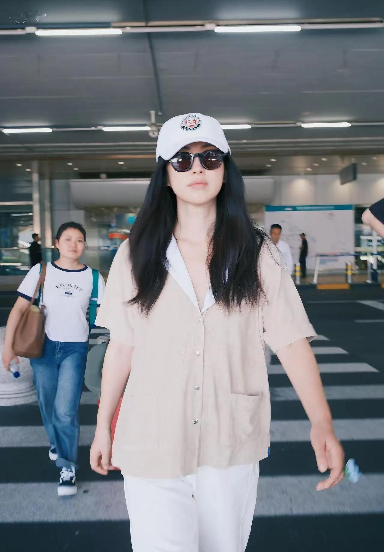 朱珠机场这套懒人穿搭太适合长途出行！
浅杏宽松短袖衬衫+纯白阔腿长裤，面料柔软透