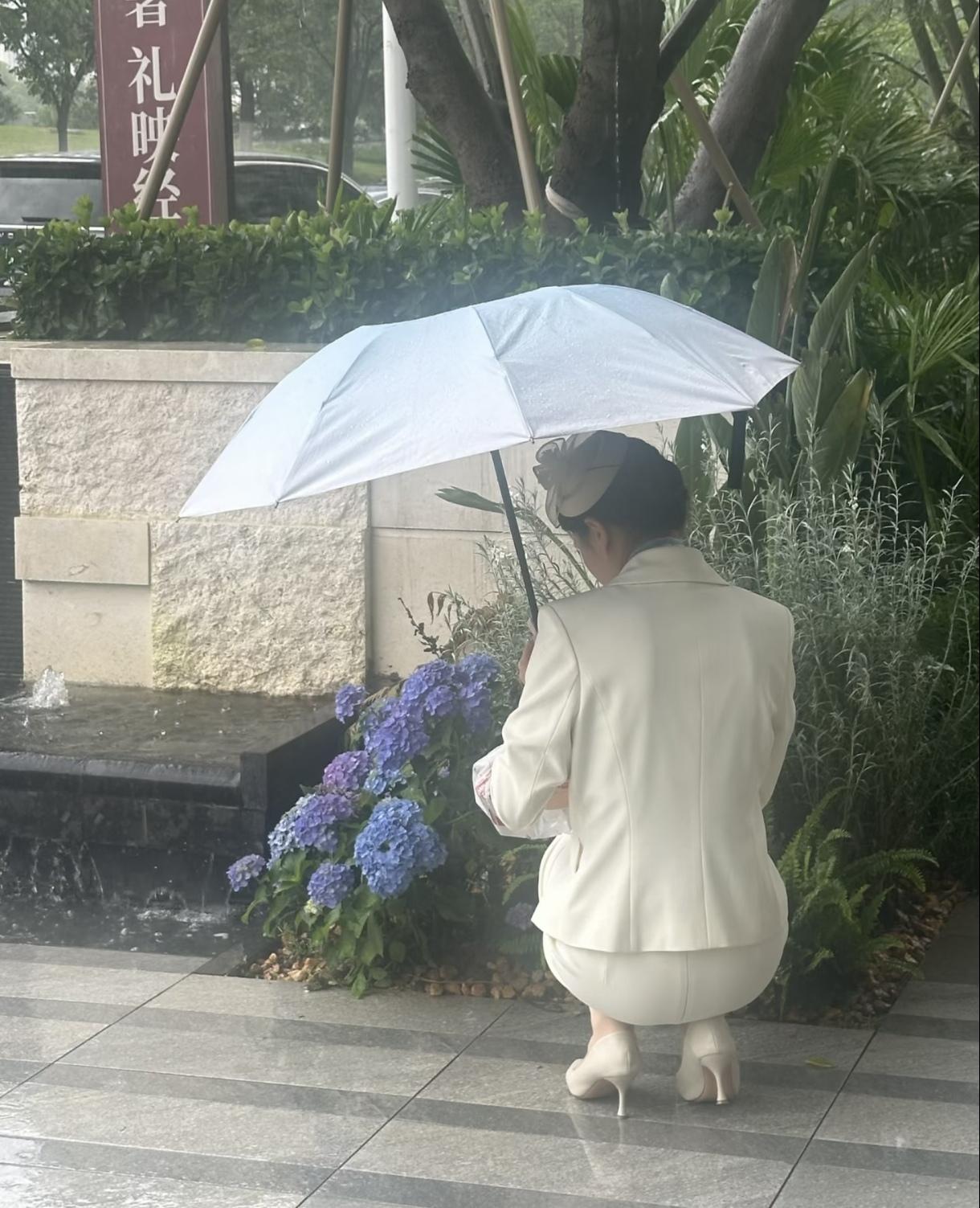 大雨冲刷街巷，物业人冒雨弯腰捡拾散落垃圾，一身雨水换小区洁净，平凡岗位藏着暖心担