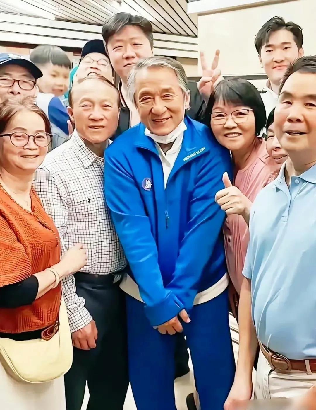 成龙大哥在人群中显得好拘谨啊，眼窝深陷，鱼尾纹凸显，头发花白，身材佝偻，确实是老