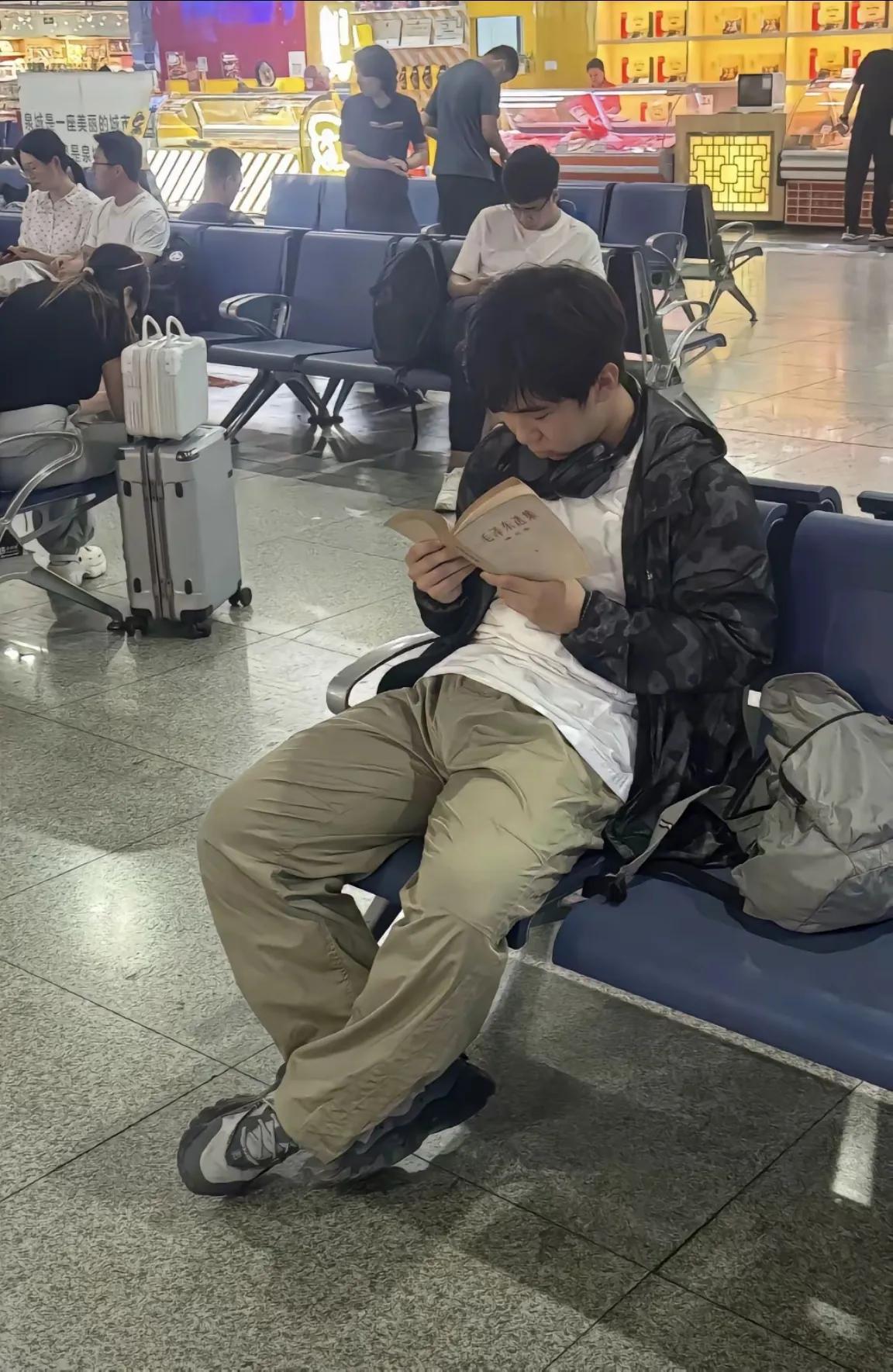火车站的候车大厅，一位00后小伙子，手捧着一本《毛泽东选集》忘我地阅读。
看到这