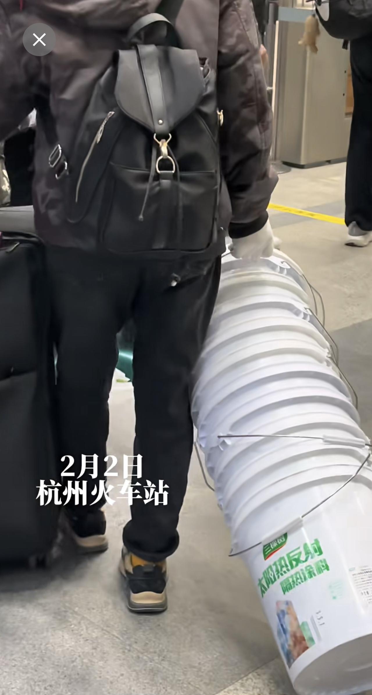 2026年春运第一天，杭州站。一位大哥带11只塑料桶回家过年。山高水远，带那么多