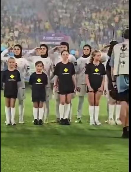 在与澳大利亚的亚洲杯比赛开始前，伊朗国家女子足球队冒着雨不仅唱了伊朗国歌，还敬军