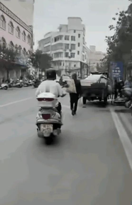 看到视频那一刻，说实话，我拳头都攥紧了。

广东高州石鼓镇，一个拾荒老人背着袋子