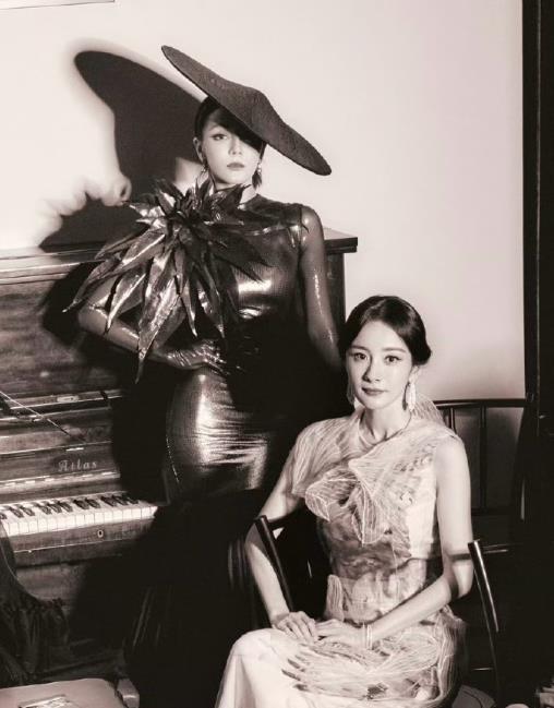 杨幂热巴合照 “大力”迪丽热巴帮收拾场地将凳子举过杨幂脑袋，杨幂回应热巴你是要砸