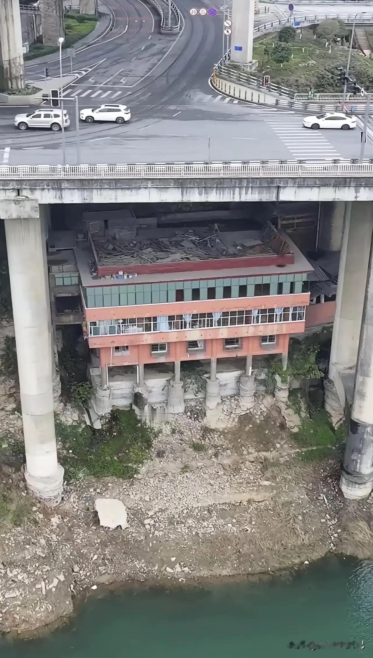 桥底下的这栋楼，位置真的独一无二，头顶就是车流不息的高架桥。
大家猜猜住在这里最