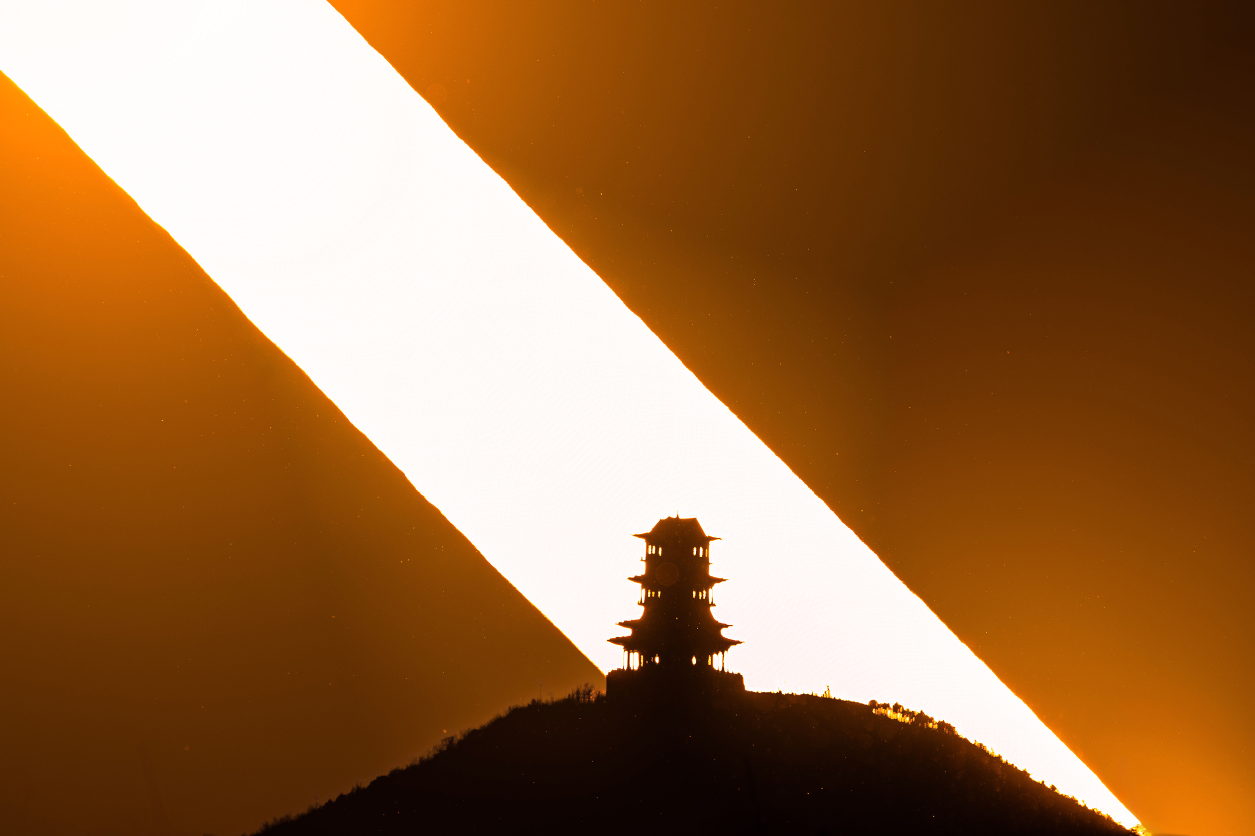 落日的光轨，像把刀，劈开天际，把生活的琐碎，塞进时光的裂缝。 