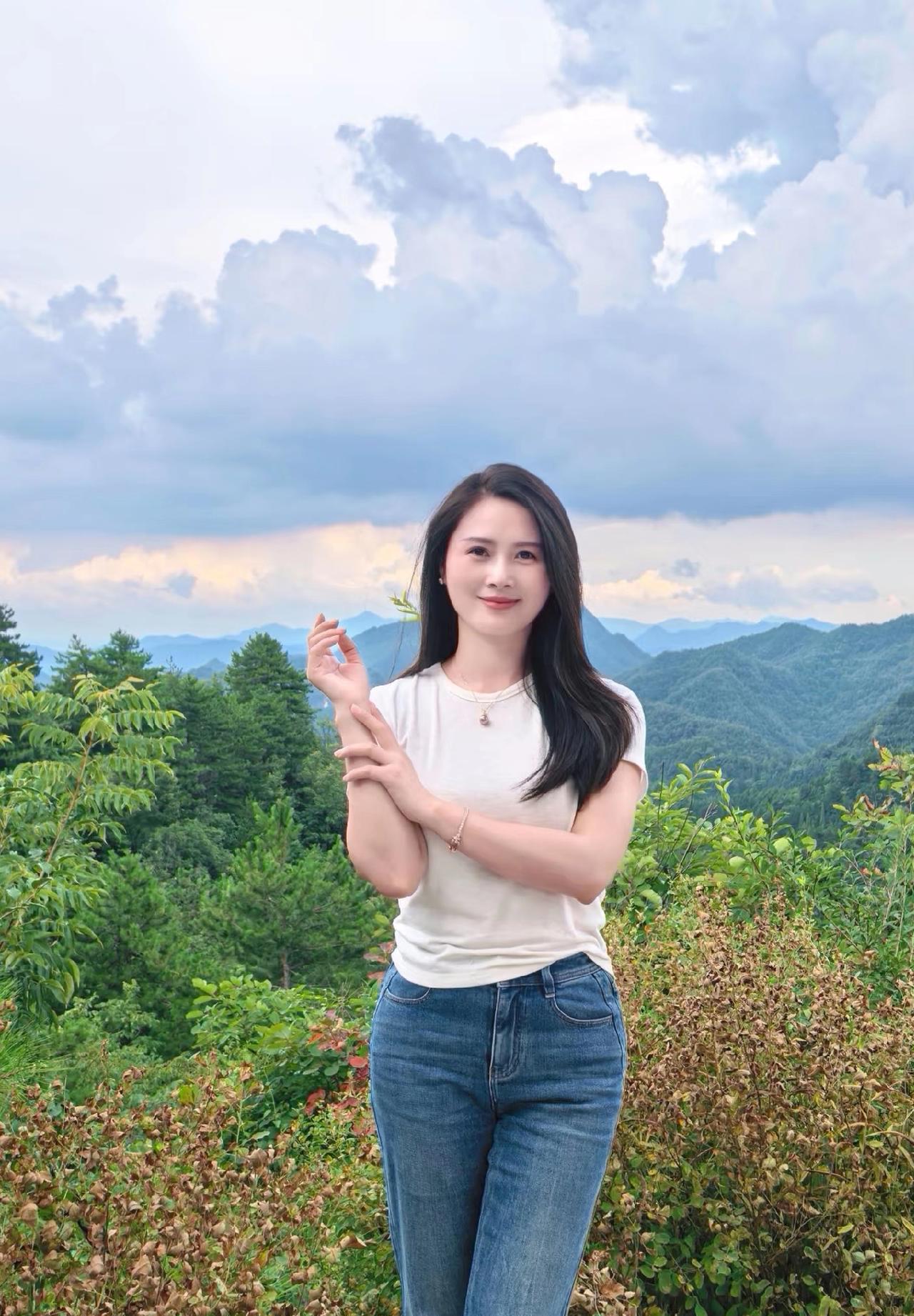 这位小姐姐在山间风景中摆姿势拍照。气质女生拍照