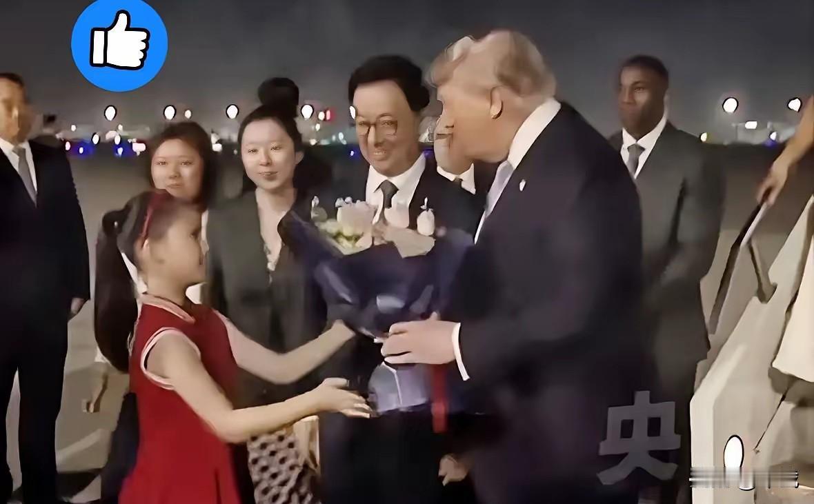 整个接机仪式中最引人注目的就是那个穿红色连衣裙的小姑娘，手里捧着花，在满是黑压压