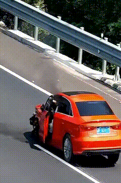 高速路上，一辆红色轿车突然失控，猛地撞向护栏，随后被反弹至路中央。司机强撑着打开