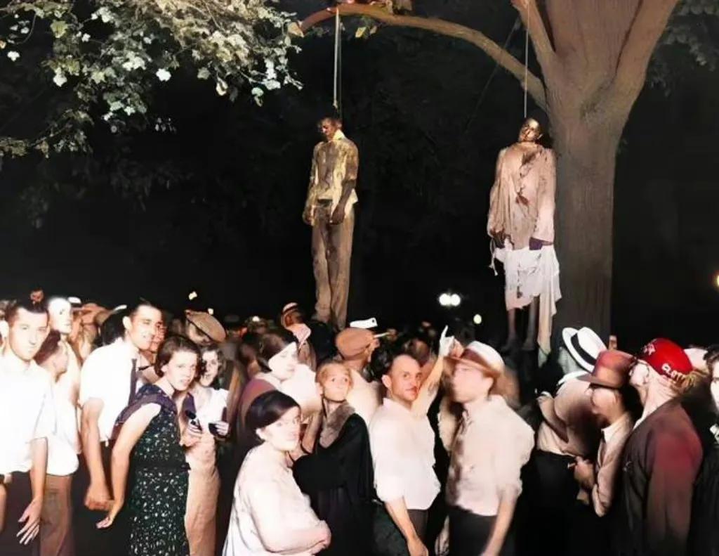 1930年，亚特兰公园，两名黑人被吊死在树上，白人在树下围观着这一切。

原来就