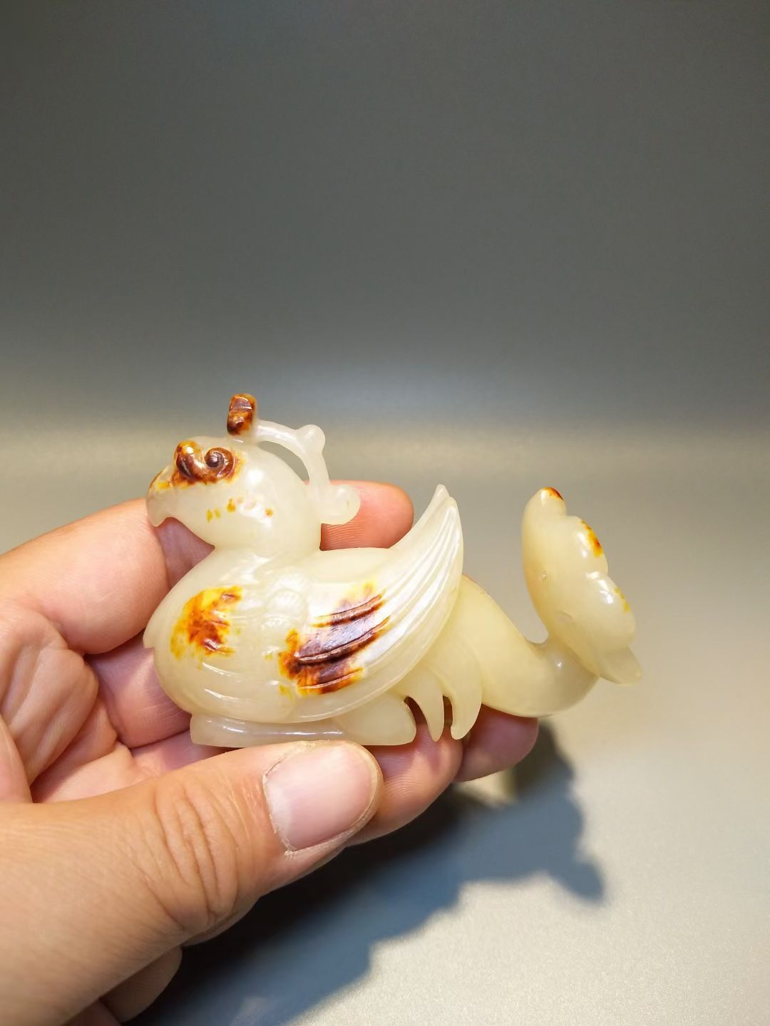 高古玉 这只汉代凤鸟，尾巴很奇葩，像孔雀开屏。沁色也浸的奇妙，也能算的上白玉红沁