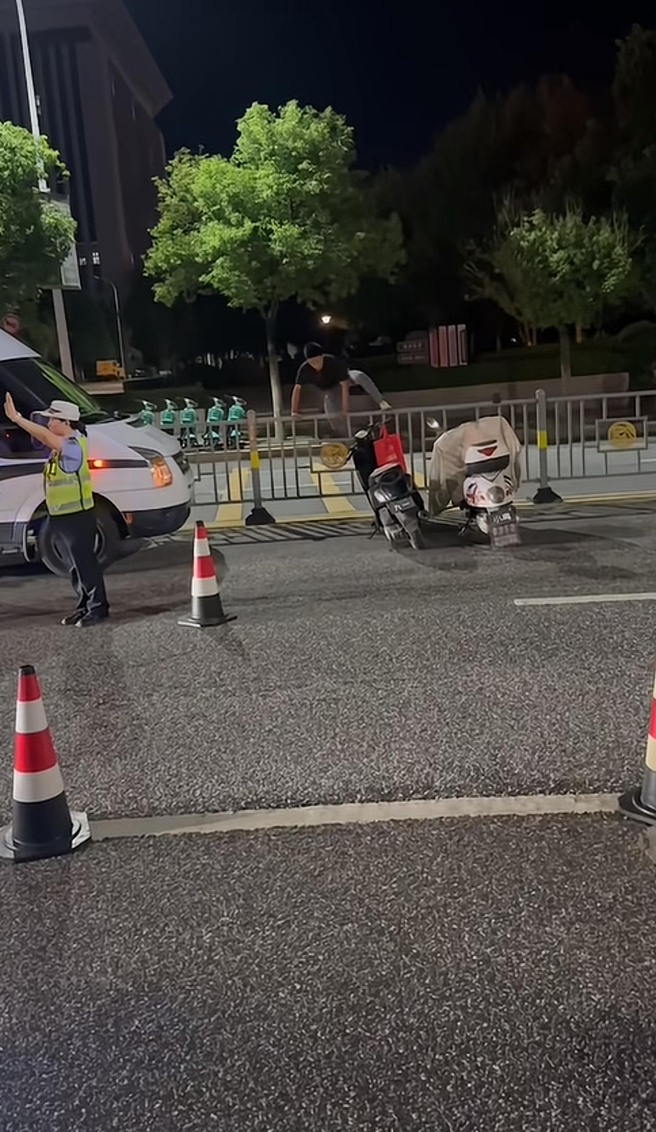 交警这边正在路口执勤拦查，小伙眼疾手快，干脆直接翻越护栏，跨到马路对面，火速骑上